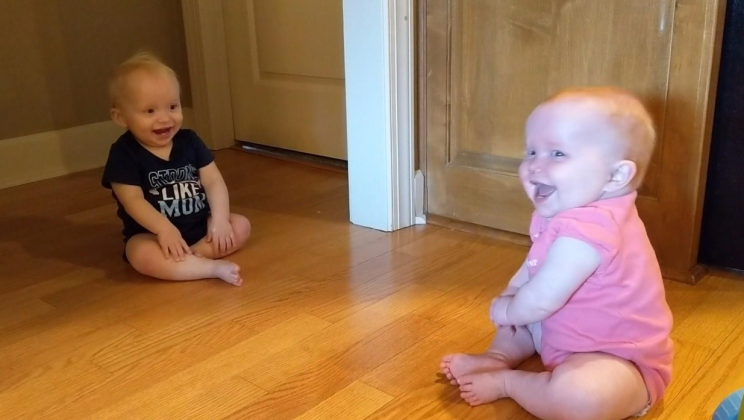 The twins are having fun. Their laughter is infectious.