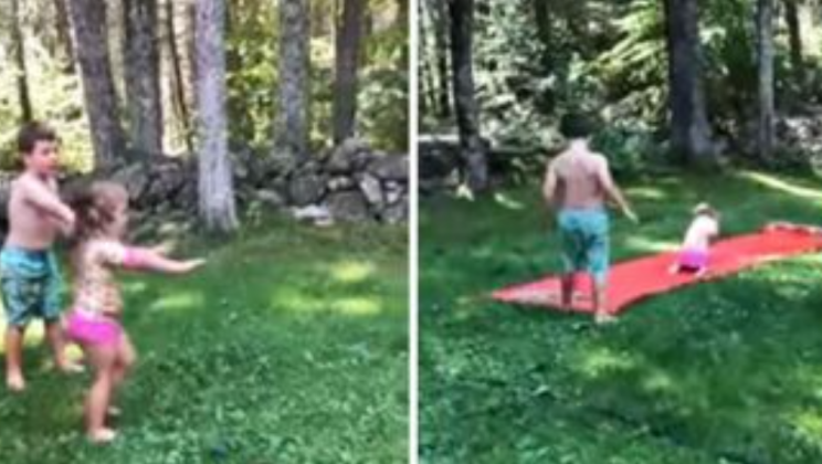 Big brother teaches sister how to sail down backyard waterslide